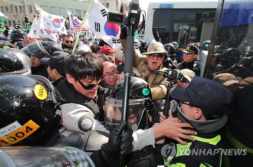 Protesters from conservative civic bodies scuffle with police at an intersection leading to the Constitutional Court in Seoul on March 10, 2017, after the court upheld the impeachment of the president. The ruling, which was announced by the court's acting chief and televised live, made Park the nation's first democratically elected leader to be ousted. (Yonhap)