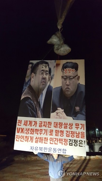 A defector activist holds up a placard denouncing Pyongyang for the killing of Kim Jong-nam in Paju, north of Seoul, on March 28, 2017. (Yonhap)