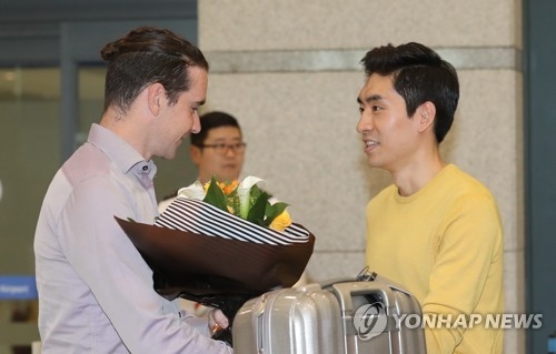 Bob de Jong (L), former Dutch speed skater named an assistant coach for the South Korean national team, receives a bouquet of flowers from South Korean skater Lee Seung-hoon after arriving at at Incheon International Airport on May 16, 2017. Lee and de Jong won gold and bronze medals in the men's 10,000 meters at the 2010 Vancouver Winter Olympics. (Yonhap)