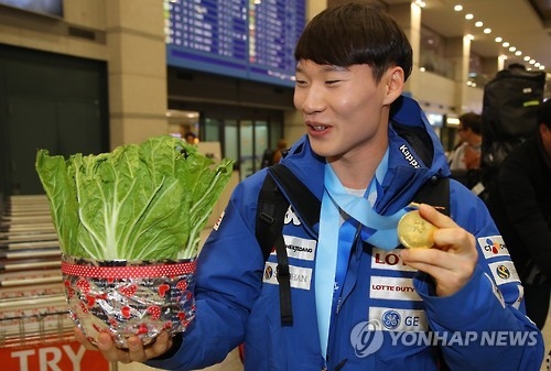 In this file photo taken Feb. 21, 2017, South Korean alpine snowboarder Lee Sang-ho holds a napa cabbage at Incheon International Airport after he returned home from the Asian Winter Games in Japan. (Yonhap)