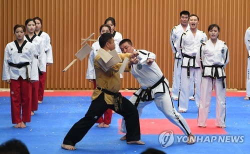 This photo, provided by a pool report, shows a joint taekwondo demonstration team of South Korea and North Korea performing at Seoul City Hall on Feb. 12, 2018. (Yonhap) 
