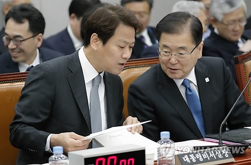 Chung Eui-yong (R), chief of the presidential National Security Office, talks with presidential chief of staff Im Jong-seok during a parliamentary steering committee meeting on Feb. 21, 2018. (Yonhap)