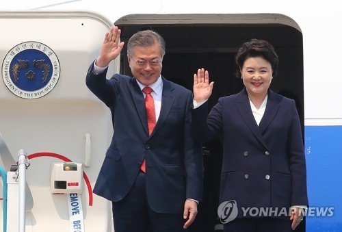 South Korean President Moon Jae-in and his wife Kim Jung-sook wave after arriving at Hanoi's Noi Bai International Airport on March 22, 2018 for a three-day state visit that will include a bilateral summit with Vietnamese President Tran Dai Quang. (Yonhap)
