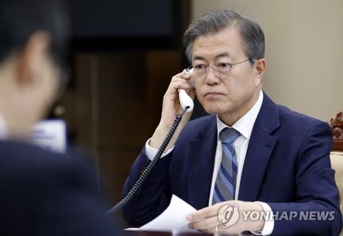 In this photo provided by the presidential office Cheong Wa Dae, South Korean President Moon Jae-in (R) has a telephone conversation with Japanese Prime Minister Shinzo Abe on April 24, 2018. (Yonhap)