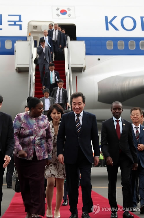 Prime Minister Lee Nak-yon walks with a Kenyan official after arriving at a Nairobi airport on July 20, 2018. (Yonhap)