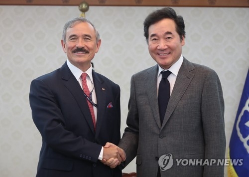 Prime Minister Lee Nak-yon (R) shakes hands with U.S. Ambassador Harry Harris during a meeting in Seoul on Aug. 8. (Yonhap)
