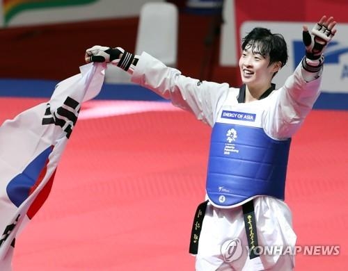 South Korean taekwondo fighter Lee Da-bin celebrates with the national flag after winning the women's over-67 kilogram division taekwondo "kyorugi" (sparring) competition at the 18th Asian Games in Jakarta on Aug. 21, 2018. (Yonhap)