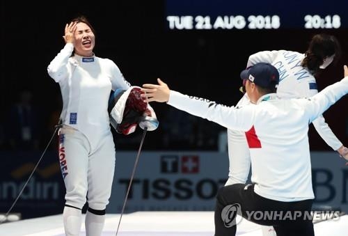 South Korean fencer Kang Young-mi (L) celebrates her gold medal in the women's individual epee competition at the 18th Asian Games at Jakarta Convention Center (JCC) Cendrawasih Hall in Jakarta on Aug. 21, 2018. (Yonhap)