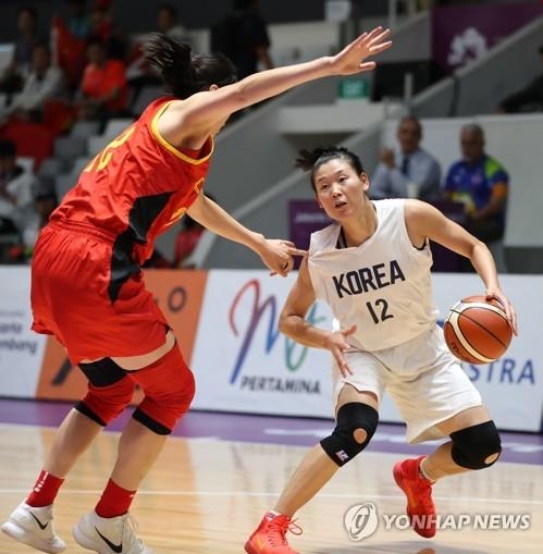 Ro Suk-yong (R), North Korean center on the unified Korean women's basketball team, dribbles the ball against China during the women's basketball final at the 18th Asian Games at GBK Istora on Sept. 1, 2018. (Yonhap)