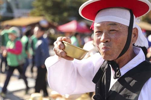 A volunteer dressed in traditional Korean dress poses for a photo during the Icheon Rice Culture Festival in Icheon, 80 kilometers south of Seoul, on Oct. 20, 2018. (Yonhap)