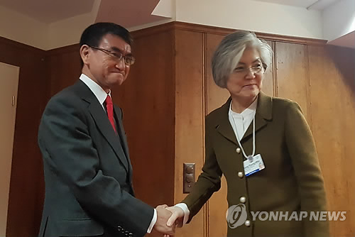 This file photo, taken Jan. 23, 2019, shows Foreign Minister Kang Kyung-wha (R) shaking hands with her Japanese counterpart, Taro Kono, before their talks on the sidelines of the World Economic Forum in Davos, Switzerland. (Yonhap)