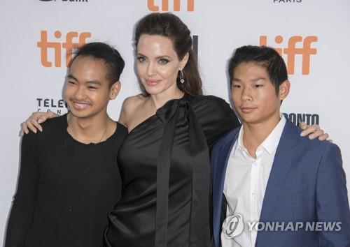 This file photo shows Angelina Jolie (C) and her sons, Maddox Jolie-Pitt (L) and Pax Jolie-Pitt, attending the Toronto International Film Festival in Toronto, Canada, on Sept. 11, 2017. (EPA-Yonhap)
