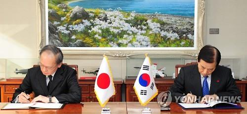 South Korean Defense Minister Han Min-koo (R) and Japanese Ambassador to South Korea Yasumasa Nagamine sign the General Security of Military Information Agreement on the sharing of military intelligence on North Korea during a ceremony at the defense ministry in Seoul on Nov. 23, 2016, in this photo released by the ministry. (PHOTO NOT FOR SALE) (Yonhap)