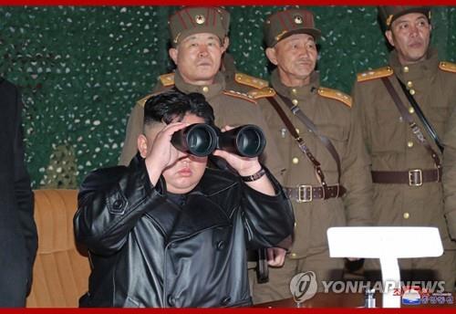This photo captured from the homepage of the Korean Central News Agency on March 22, 2020, shows North Korean leader Kim Jong-un using binoculars to observe a test of a newly developed tactical weapon the previous day. (For Use Only in the Republic of Korea. No Redistribution) (Yonhap)