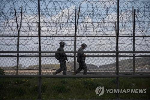 This AFP photo, taken on April 23, 2020, shows South Korean soldiers patrolling along a barbed wire fence in the Demilitarized Zone (DMZ) separating North and South Korea, on the South Korean island of Ganghwa. (Yonhap)