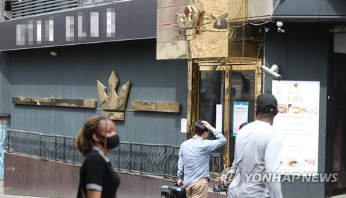 People walk past a dance club in the popular international district of Itaewon in Seoul on May 7, 2020. The club was shut down, as a man in his 20s who tested positive for COVID-19 visited the place on May 1. Some 500 people were reportedly there at that time. (Yonhap)