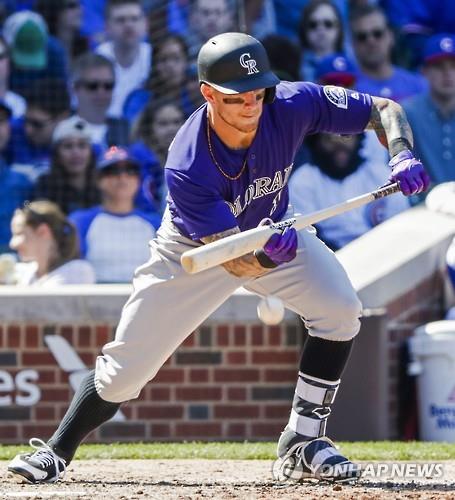 In this EPA file photo from April 17, 2016, Brandon Barnes of the Colorado Rockies attempts a bunt against the Chicago Cubs during their Major League Baseball regular season game at Wrigley Field in Chicago. (Yonhap)