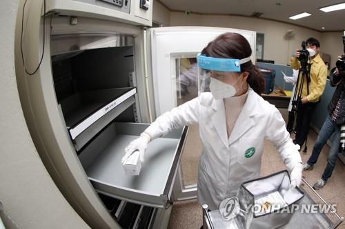 A medical worker moves a box containing doses of AstraZeneca's COVID-19 vaccines to a container at a public health center in Gwangju, 330 kilometers south of Seoul, on Feb. 25, 2021. The country's vaccinations will begin the following day. (Yonhap)