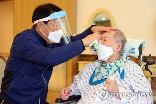 A man wipes away his wife's tears at a nursing home in Gwangju, Gyeonggi Province, on Sept. 20, 2021. The couple met in person for the first time in two months as the government has enforced special quarantine steps for the Chuseok holiday amid the new coronavirus, in this photo provided by the health ministry. (PHOTO NOT FOR SALE) (Yonhap)