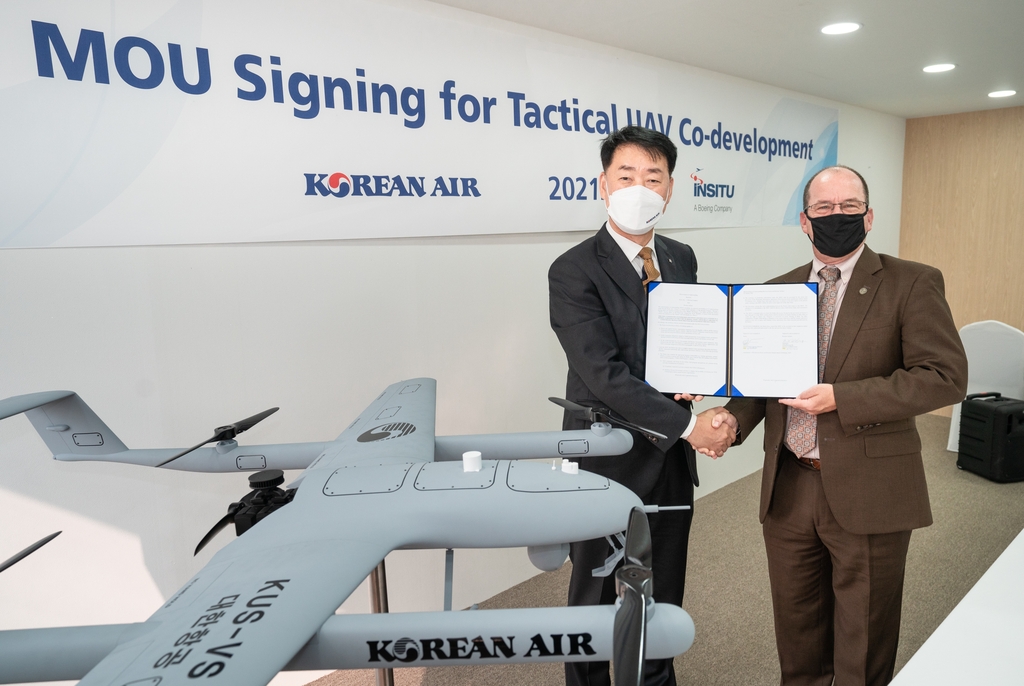 This photo taken on Oct. 21, 2021, shows Park Jung-woo (L), senior vice president of Korean Air's Aerospace Business Division, and Randy Rotte, regional director in charge of Asia-Pacific sales at Insitu after the MOU ceremony for UAV cooperation at the 2021 Seoul International Aerospace and Defense Exhibition. (PHOTO NOT FOR SALE)(Yonhap) 