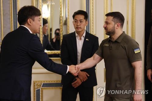 This file photo provided by the ruling People Power Party (PPP), unrelated to the article, shows PPP Chairman Lee Jun-seok (L) shaking hands with Ukrainian President Volodymyr Zelenskyy at an undisclosed location in Ukraine on June 6, 2022. (PHOTO NOT FOR SALE) (Yonhap)