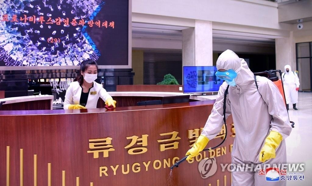 In this photo released by the North's official Korean Central News Agency on June 15, 2022, North Korean workers disinfect public areas of the Ryugyong Golden Mall in Pyongyang. (For Use Only in the Republic of Korea. No Redistribution) (Yonhap)