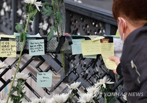 A man posts a condolence message on Nov. 1, 2022, near Itaewon Station for those killed in the Halloween crowd crush in the neighborhood three days ago. (Yonhap)