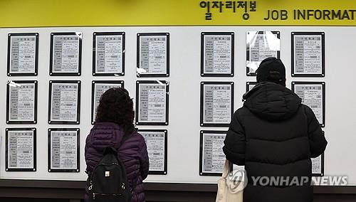 In this file photo, people check job posts at an employment center in Seoul on Feb. 16, 2024. (Yonhap)