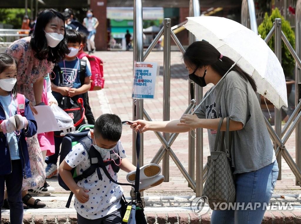 Une femme vient chercher son fils dans une école primaire à Gwangju, à 330 km au sud-ouest de Séoul, le jeudi 28 mai 2020.