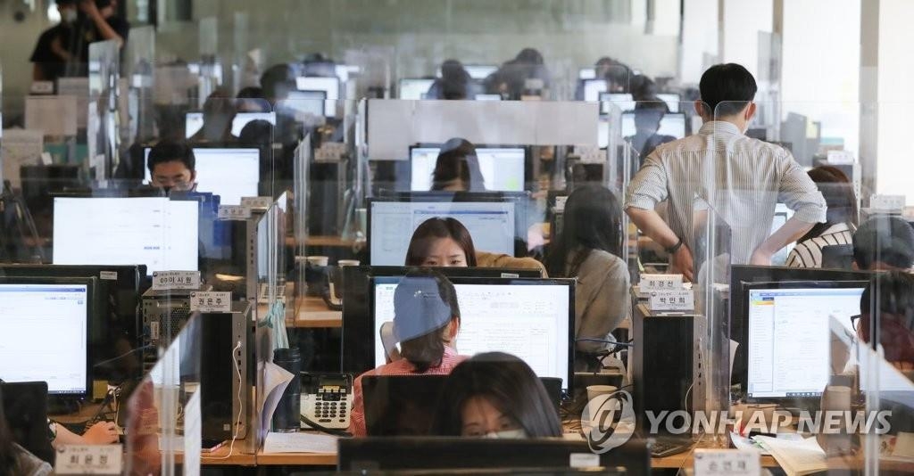 Des employés travaillent dans un bureau, au centre de Séoul, le mercredi 3 juin 2020, alors que leurs bureaux sont séparés par des écrans de protection.