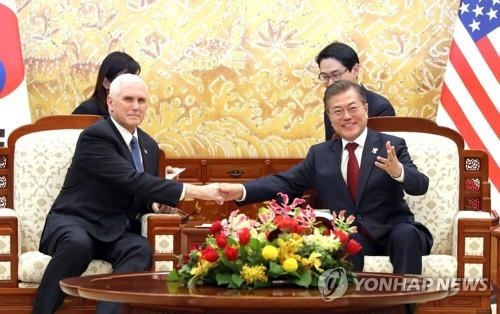 ペンス副大統領（左）と握手する文大統領＝８日、ソウル（聯合ニュース）