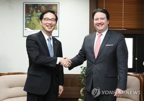 握手を交わす千次官（左）とナッパー駐韓米国大使代理（統一部提供）＝１４日、ソウル（聯合ニュース）