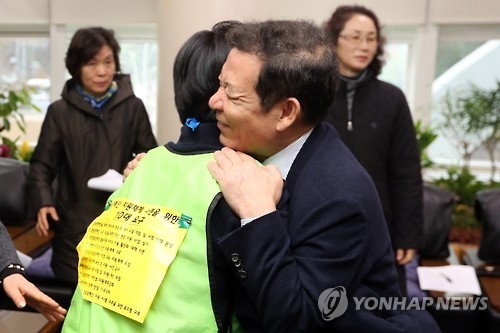 윤장현 광주시장(오른쪽)이 22일 집무실에서 장애인단체 회원을 안아주고 있다.