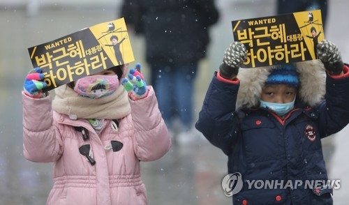 (서울=연합뉴스) 한상균 기자 = 올 겨울 첫 눈이 내린 26일 박근혜 대통령 하야 촉구 촛불집회가 예정된 광화문에서 어린이들이 피켓을 들고 있다. 2016.11.26xyz@yna.co.kr