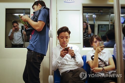 출퇴근 시간에 휴대전화를 들여다보는 태국 방콕 시민들