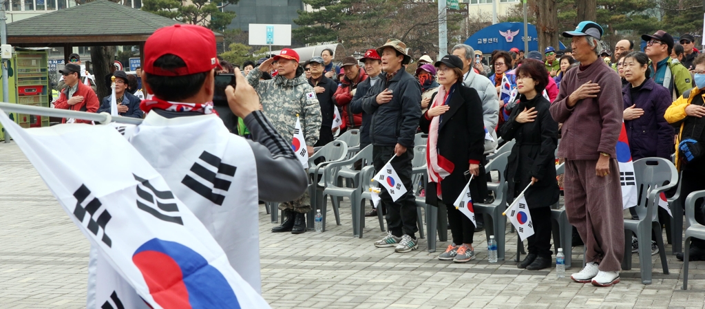 국기에 경례하는 집회참석자들