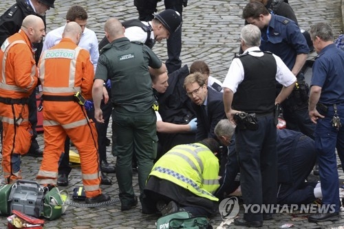 엘우드 외무차관이 런던테러로 부상한 경찰관을 응급처치하고 있다