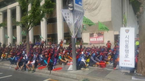 (서울=연합뉴스) 21일 오전 세종문화회관 인도에 앉아있는 건설노조원들.