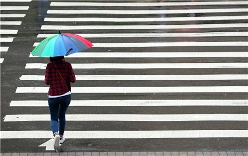 한 시민이 우산을 쓰고 출근합니다. /김인철