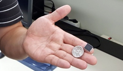 ETRI에서 개발한 시각지능 칩 크기를 100원짜리 동전과 비교한 모습. 실제 칩의 크기는 가로와 세로 각각 5㎜ 정도이나, 사진 속 칩은 보호막을 한 상태라고 연구진은 설명했다. [ETRI 제공=연합뉴스]