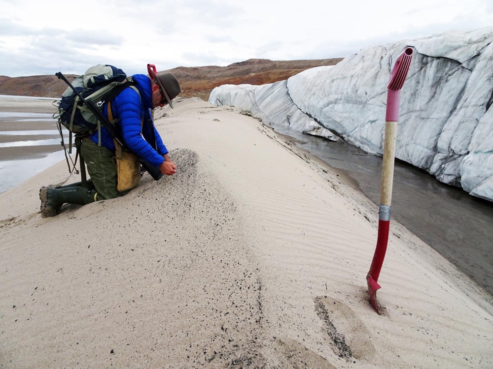운석 충돌구에서 얼음 가장자리로 흘러나온 규사 샘플을 수집하는 크재르 박사 