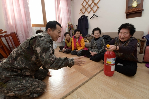 마을복지회관 어르신에게 소화기 사용법을 설명하는 1전비 박원철 준위