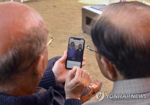 라시드의 고향인 파키스탄 압봇타바드에서 그의 사진을 보는 사람들