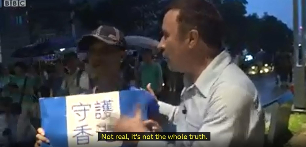 20일(현지시간) 홍콩에서 열린 친중파 집회 소식을 전하던 BBC 중국 특파원 스티븐 맥도넬 기자가 집회 참가자로부터 가짜뉴스라는 이야기를 듣는 장면. [BBC 화면 캡처=연합뉴스]