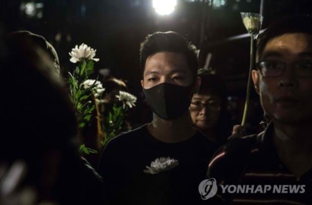 시위 희생자를 추모하며 조화를 들고 있는 홍콩 시민들