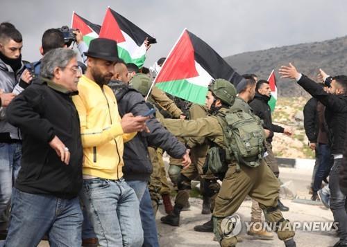 29일(현지시간) 요르단강 서안에서 팔레스타인 시위대와 이스라엘 군인들이 몸싸움하고 있다.[EPA=연합뉴스]