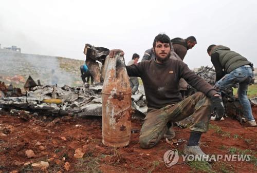 14일 격추된 정부군 헬기의 잔해를 보여주는 시리아 반군