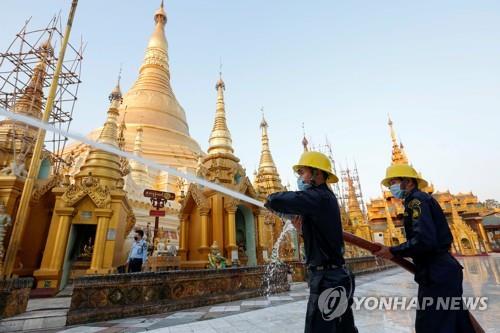 보건 관계자들이 미얀마 상징인 쉐다곤탑 방역 작업을 진행 중인 모습 2020.3.25