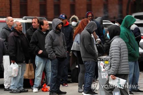 코로나19가 강타한 미국에서 지난 25일 사람들이 무료 급식을 받기 위해 길게 줄 서 있다. [로이터=연합뉴스 자료사진]