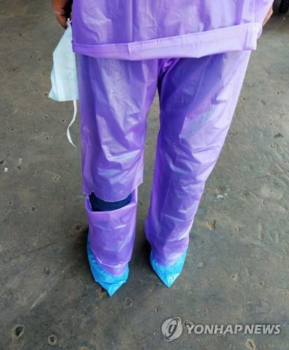 3월 26일 의료 보호장구 대신 찢어진 비옷을 입은 인도 콜카타의 한 의사. [로이터=연합뉴스]